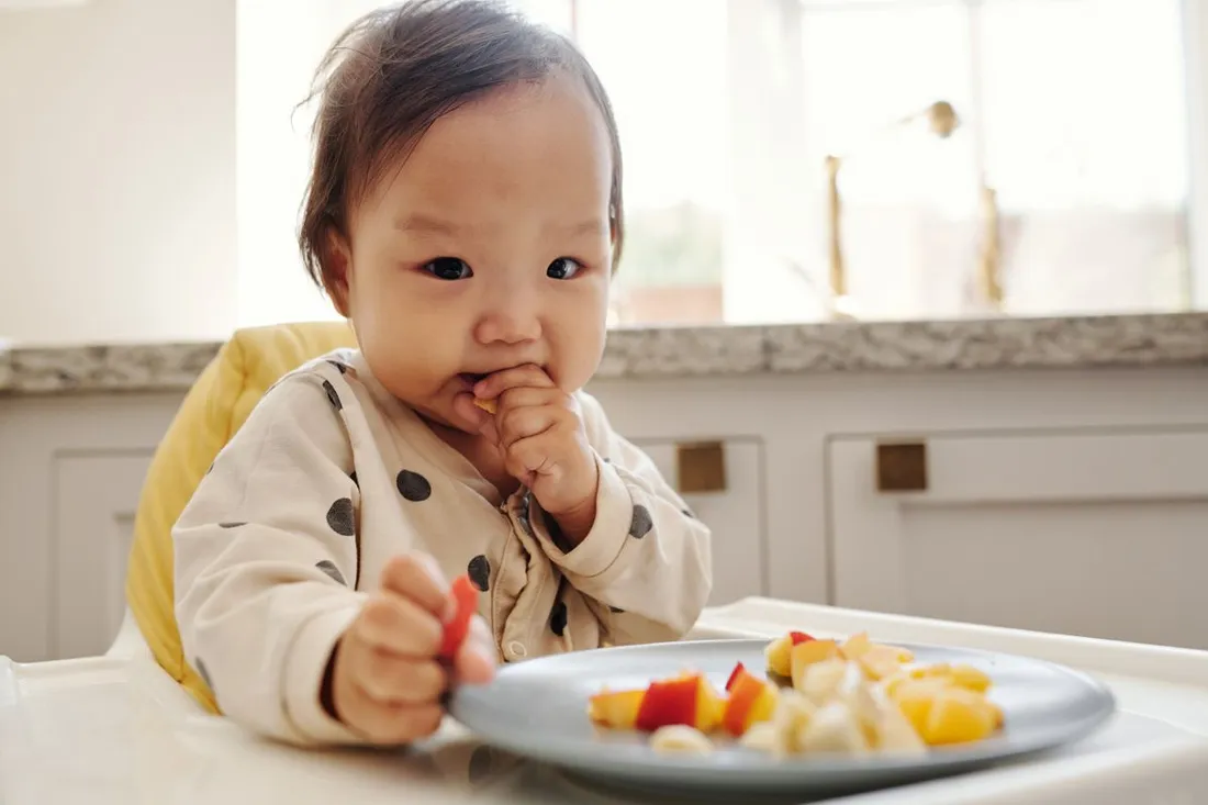 A young child eating fresh fruit