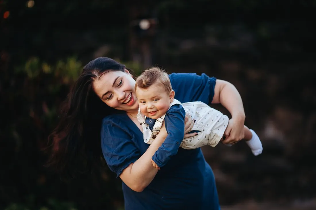 A mother holding her baby in warm light